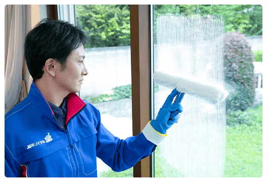 部屋の窓を道具を使って綺麗にしている様子